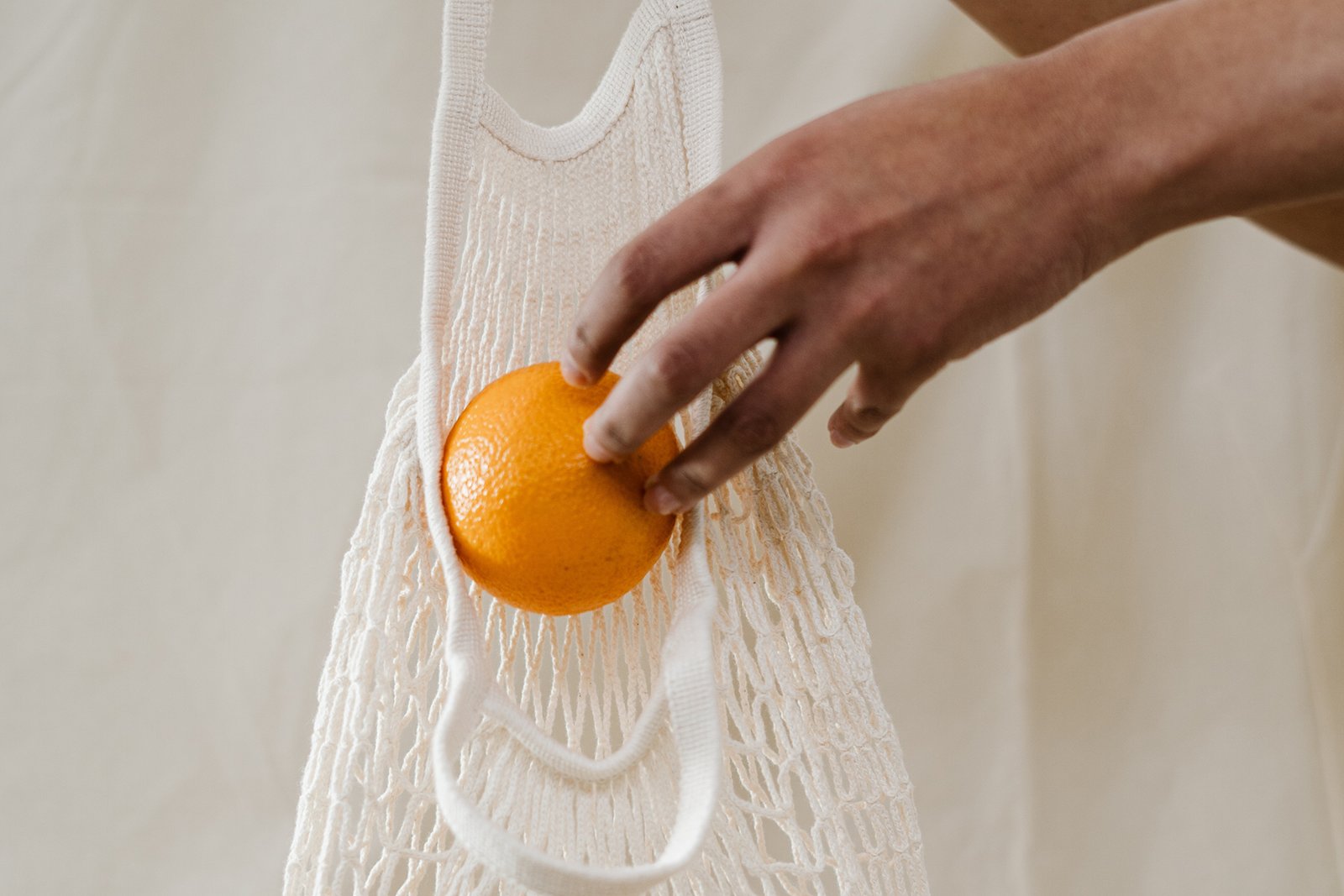 orange being placed in a bag